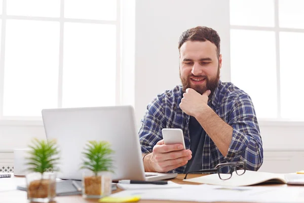 Ontspannen jonge zakenman mobiele gebruiken in office — Stockfoto