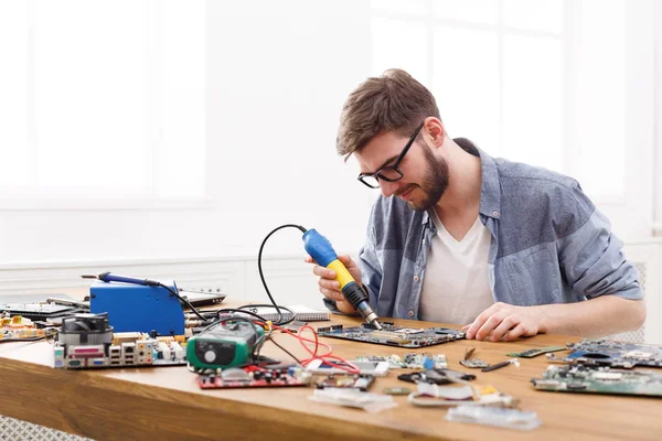 Technician repairing motherboard by air dryer — Stock Photo, Image