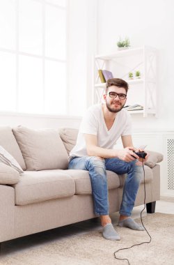 Mutlu genç adam evde video oyunları oynarken