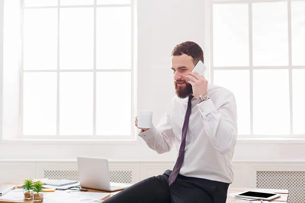 Серьезный бизнесмен в формальной одежде с ноутбуком в современном белом офисе — стоковое фото