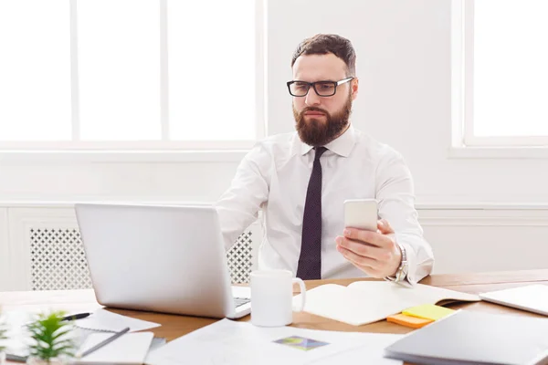 Seriös affärsman med laptop i modern vit office — Stockfoto