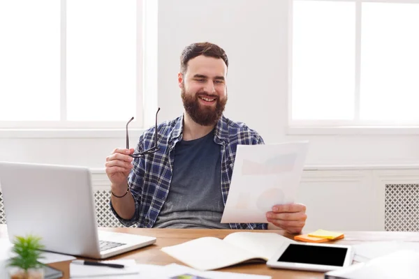 Feliz hombre de negocios leyendo documentos en blanco oficina moderna — Foto de Stock