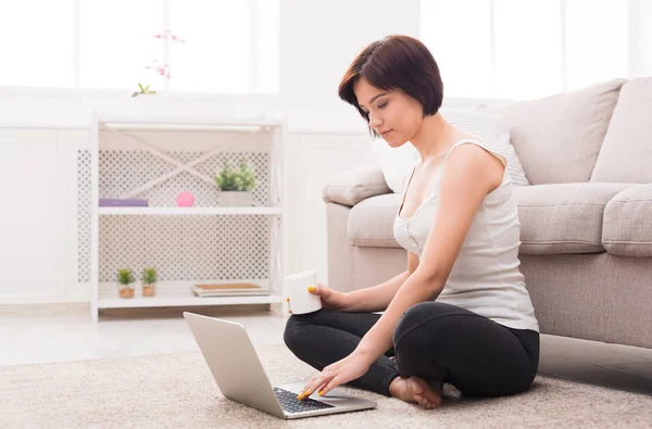 Ragazza attraente con il computer portatile sul pavimento — Foto Stock