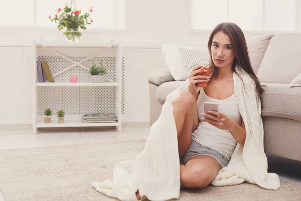 Cozy home. Girl in plaid with mobile — Stock Photo, Image