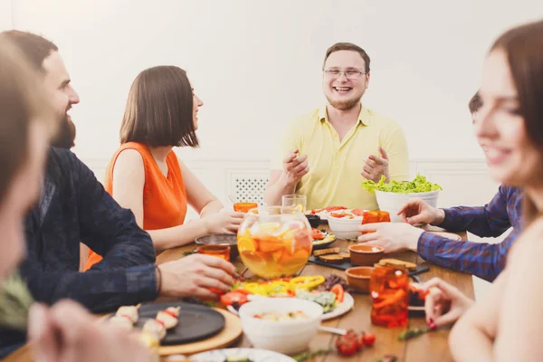 Group of happy people at festive table dinner party