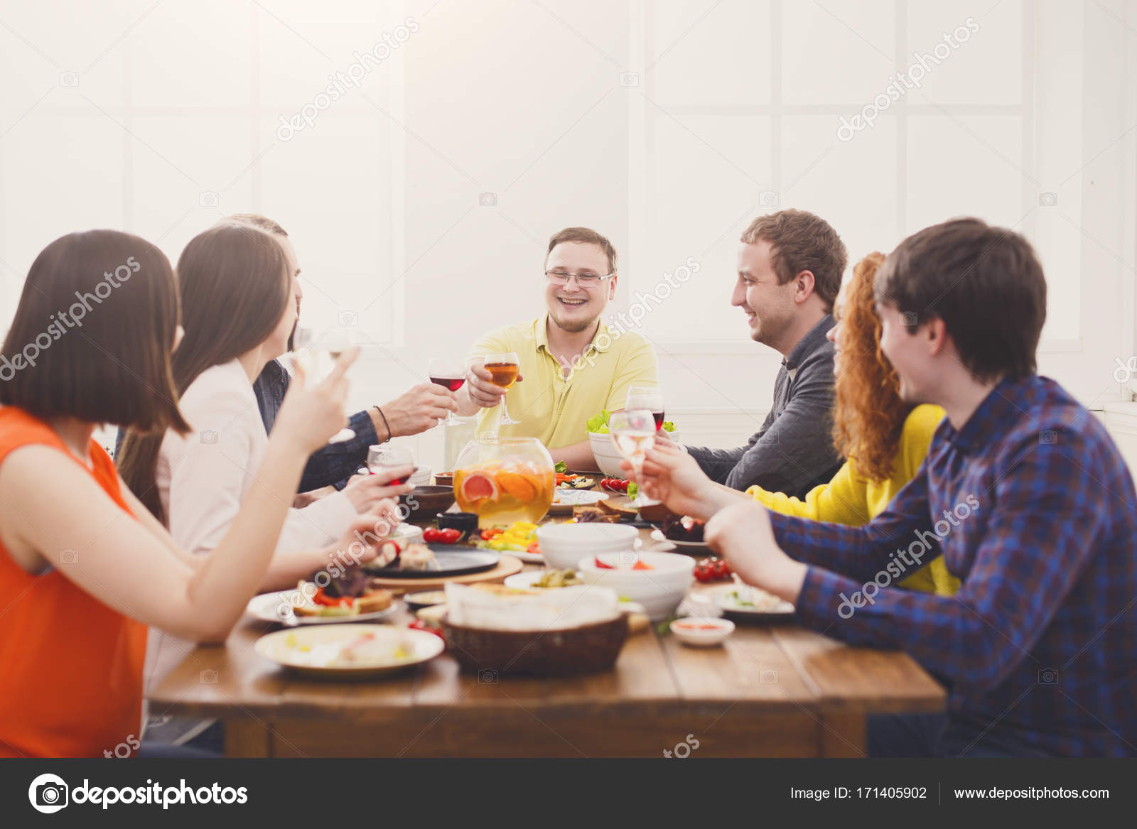 People say cheers clink glasses at festive table dinner party Stock