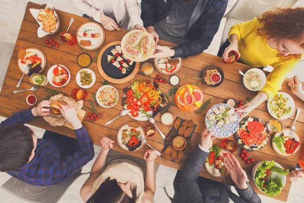 Mensen eten en delen van gezonde maaltijden op tafel geserveerd diner — Stockfoto