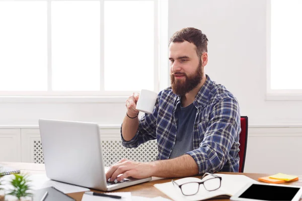 Empresário satisfeito com laptop no escritório branco moderno — Fotografia de Stock