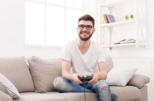 Feliz joven en casa jugando videojuegos — Foto de Stock