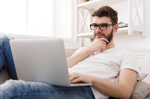 Jonge man thuis berichten online op laptop — Stockfoto