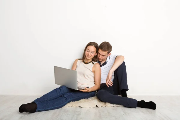Glada par använder laptop hemma, kopiera utrymme — Stockfoto