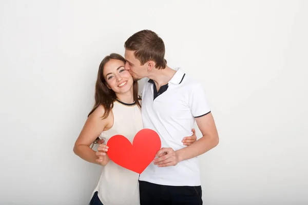 Jeune couple heureux amoureux tenant coeur de papier rouge — Photo
