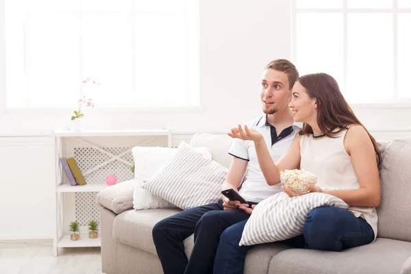 Sonriendo joven pareja viendo la televisión en casa — Foto de Stock