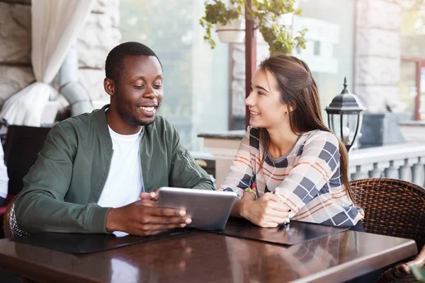 Young couple using digital tablet in cafe — Stock Photo, Image