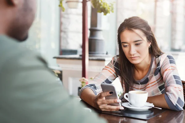 Joven chica aburrida bebiendo café en una cita en un café —  Fotos de Stock