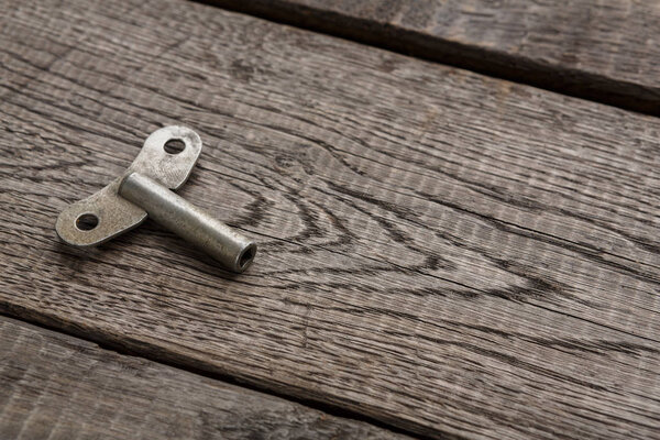 Винтажный ключ обмотки часов на деревенском дереве
