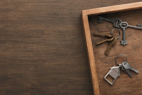 Mnoho různých klíčů na dřevěný tác — Stock fotografie