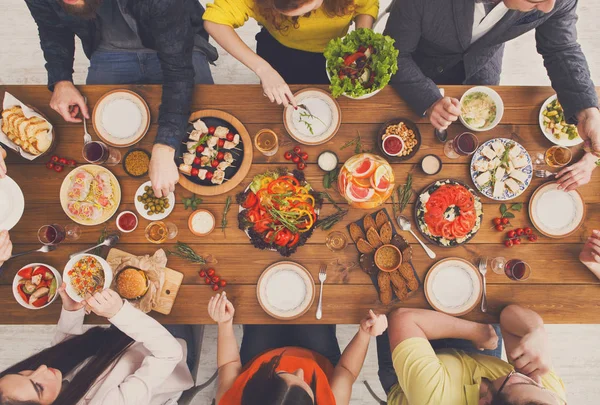 Mensen eten gezonde maaltijden op tafel geserveerd diner — Stockfoto