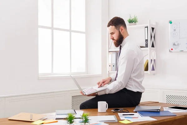 Pensativo hombre de negocios con portátil en la oficina blanca moderna — Foto de Stock