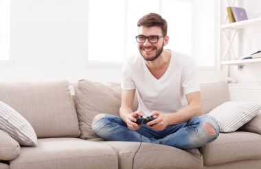 Mutlu genç adam evde video oyunları oynarken