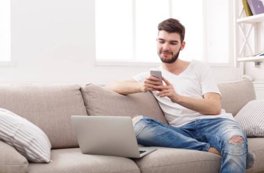 Genç adam evde online üstünde laptop mesajlaşma