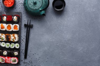 Üstten Görünüm suşi maki ve rulo rustik gri ve susam arka plan üzerinde kümesi