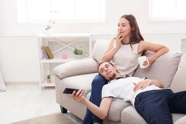 Smiling young couple watching TV at home — Stock Photo, Image