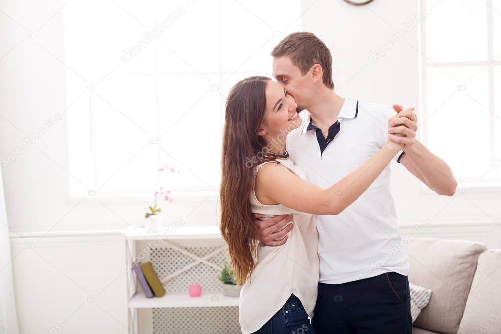 Young couple dancing at home, copy space