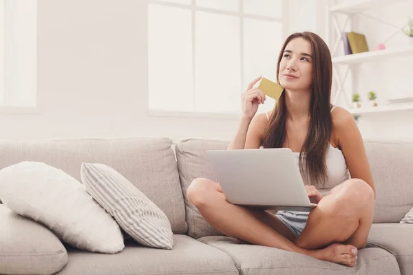 Nadenkend vrouw winkelen online met credit card — Stockfoto