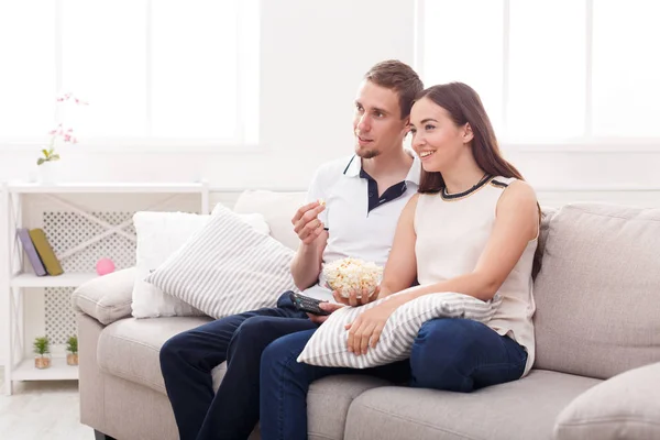 Sorrindo jovem casal assistindo TV em casa — Fotografia de Stock