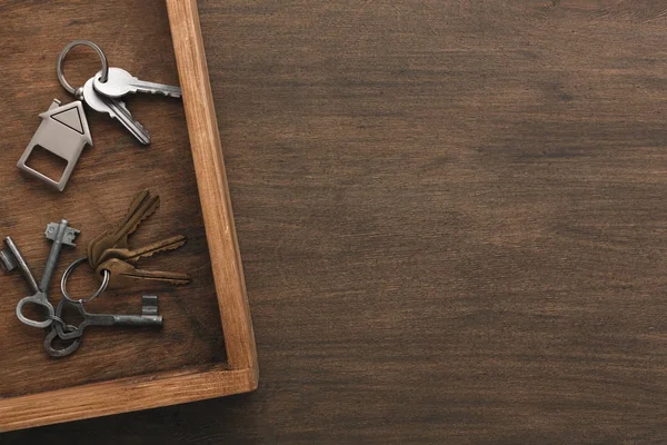 Many different keys on wooden tray — Stock Photo, Image