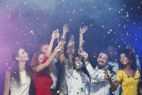 Happy young friends celebrating christmas at night club — Stock Photo, Image