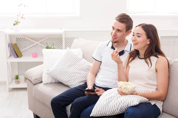 Smiling young couple watching TV at home — Stock Photo, Image