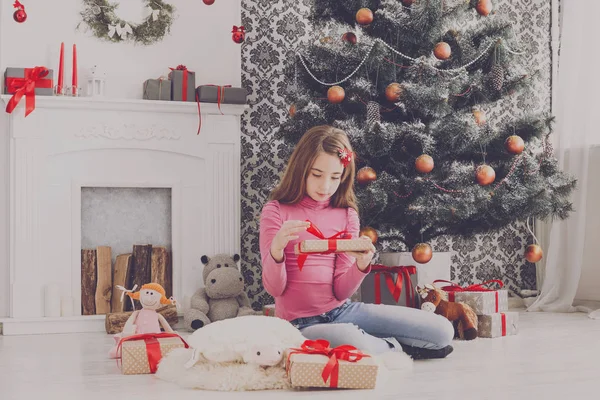 Carino ragazza scartando regali di Natale — Foto Stock