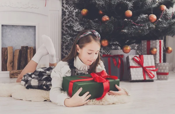 美丽的小女孩和圣诞节目前在室内 — 图库照片