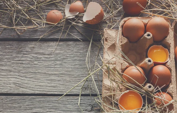 stock image Fresh chicken brown eggs in carton on rustic wood background