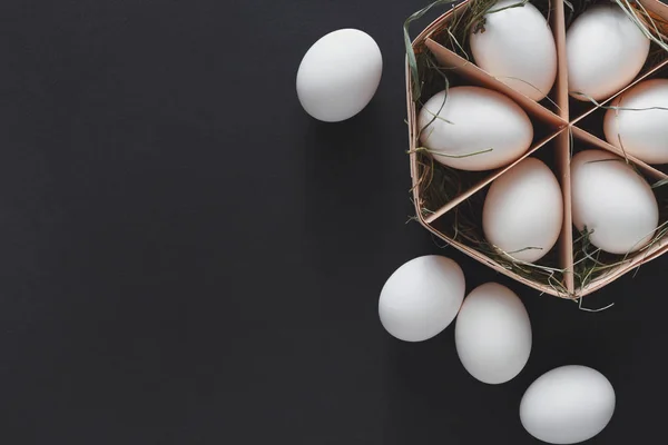 黒い背景にカートンで新鮮な鶏の白卵 — ストック写真