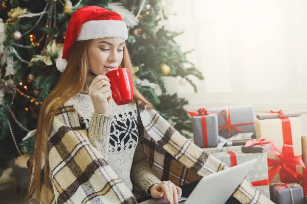 Young woman online on laptop at christmas interior — Stock Photo, Image