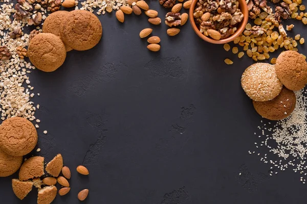 Flat lay oat cookies and nuts on dark background — Stock Photo, Image