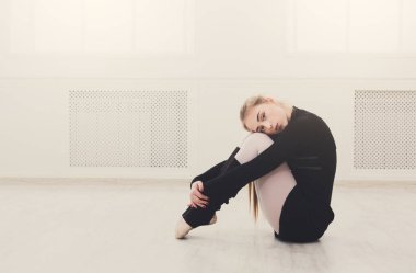 Beyaz eğitim sınıfında uzanan klasik bale dansçısı