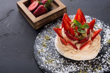 Anna Pavlova pasta siyah arka plan üzerine çilek ile