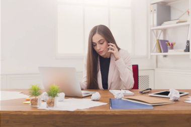 Ciddi iş kadını telefonda konuşurken iş başında