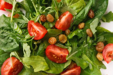 Taze salata yeşillikleri, domates ve kuru üzüm, closeup ile.