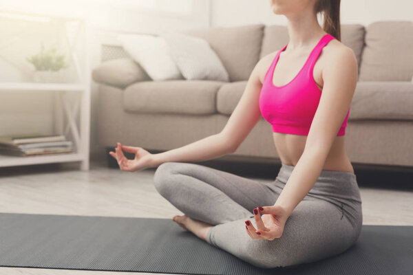 Woman training yoga in lotus pose, closeup