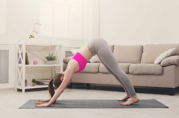 Mujer entrenando yoga en pose de perro . — Foto de Stock