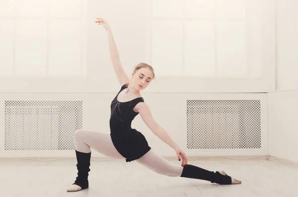 Bailarina de ballet clásica estirándose en clase de entrenamiento blanco —  Fotos de Stock