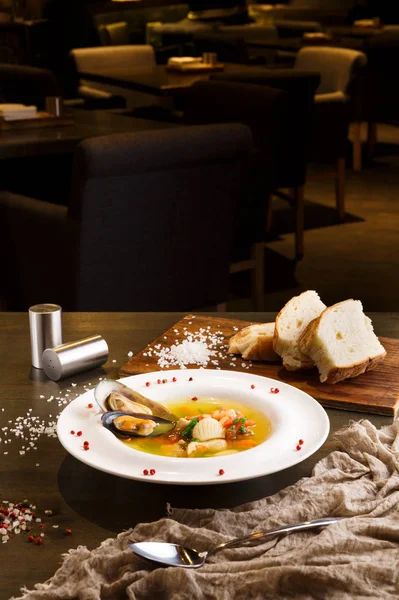 Sopa de frutos do mar francês com peixe branco, camarões e mexilhões em placa no fundo de madeira — Fotografia de Stock