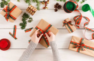 Eller, dağınık masa artalanını Xmas hediye paketleme