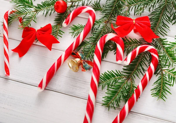 Kerstmis achtergrond met snoepjes en fir tree grens op hout — Stockfoto