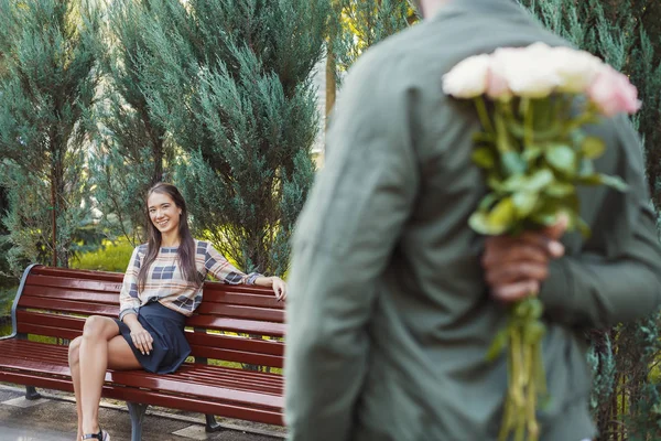 Baksidan på mannen som innehar blommor för flickvän — Stockfoto